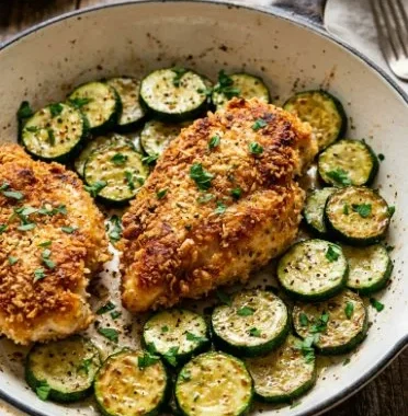 Crispy Parmesan Garlic Chicken served with zucchini on a plate.