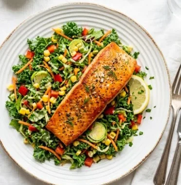 Grilled salmon salad with kale, corn, and parmesan on a plate