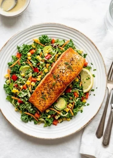 Grilled salmon salad with kale, corn, and parmesan on a plate