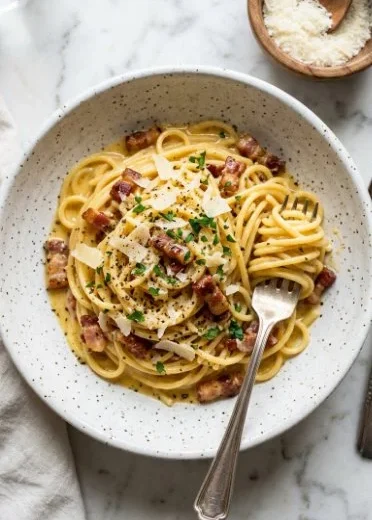 Bowl of homemade spaghetti carbonara topped with parmesan and parsley