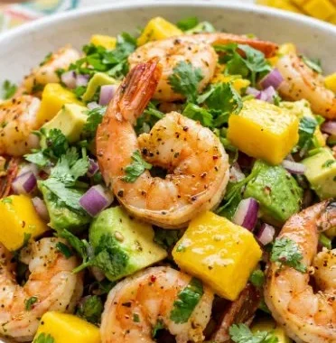 Mango pineapple shrimp salad served in a bowl with fresh ingredients and vibrant colors.