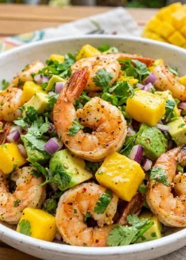 Mango pineapple shrimp salad served in a bowl with fresh ingredients and vibrant colors.