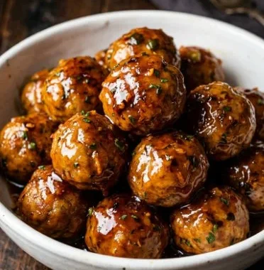 Orange Chicken Meatballs 1 Orange Chicken Meatballs served with a savory sauce and garnished with green onions