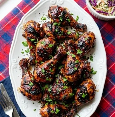 Oven Baked BBQ Chicken Legs & Thighs 2 Oven baked BBQ chicken legs and thighs served with a side dish