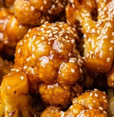 Vegan Glazed Orange Cauliflower Chicken 1 Bowl of vegan glazed orange cauliflower chicken with vibrant colors and garnishes