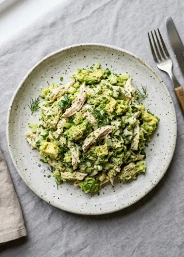 A vibrant avocado chicken salad with fresh ingredients and a creamy dressing.