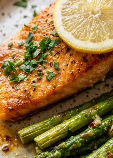 Baked salmon in foil with garlic butter and asparagus on a plate