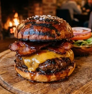 Delicious BBQ Bacon Cheese Burgers on a grill with toppings