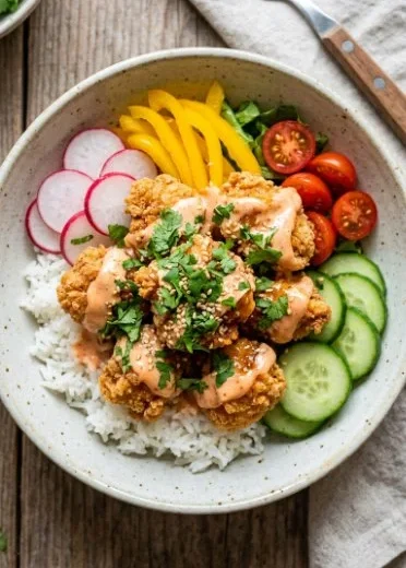 Crispy Bang Bang Chicken served in a colorful rice bowl