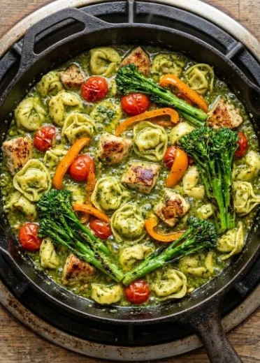 Easy pesto chicken tortellini with fresh vegetables on a plate.