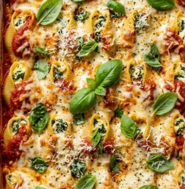Plated high-protein pesto beef stuffed shells with a sprinkle of cheese and herbs