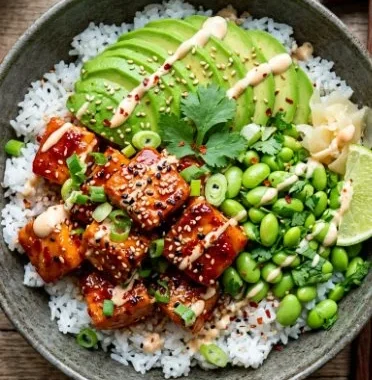 Delicious Honey Sriracha Salmon Bowls garnished with vegetables and herbs.