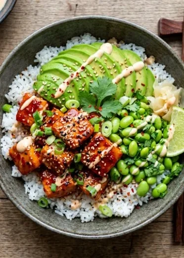 Delicious Honey Sriracha Salmon Bowls garnished with vegetables and herbs.