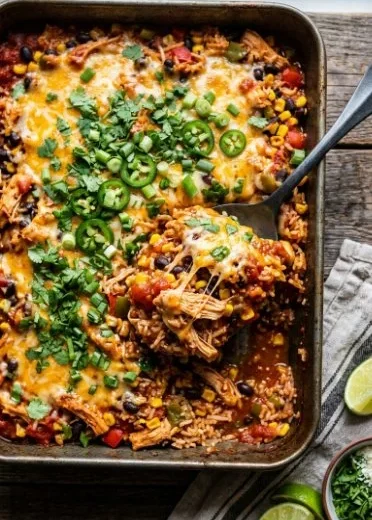 Delicious Mexican Chicken Casserole topped with cheese and colorful vegetables.