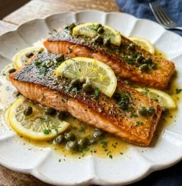 Quick Baked Salmon with Lemon Caper Sauce 2 Delicious quick baked salmon topped with lemon caper sauce on a plate