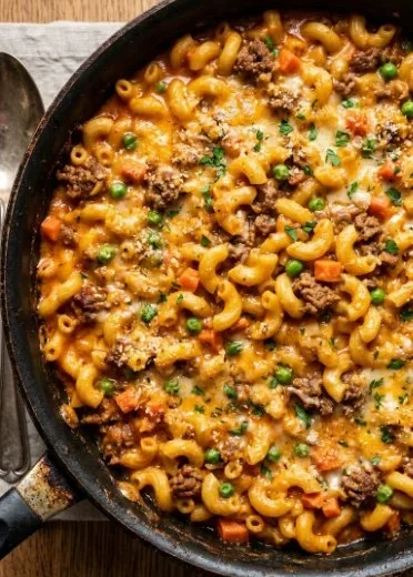 Delicious Shipwreck Hamburger Casserole topped with melted cheese and vegetables.
