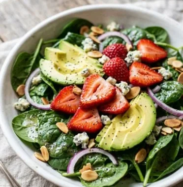 Strawberry Avocado Spinach Salad 2 Colorful strawberry avocado spinach salad topped with nuts and dressing