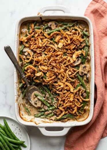 Vegan green bean casserole topped with crispy onions and mushrooms