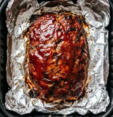Delicious air fryer meatloaf served with mashed potatoes and green beans.