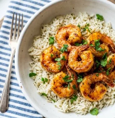 Delicious Cajun shrimp served over fluffy buttery rice dish