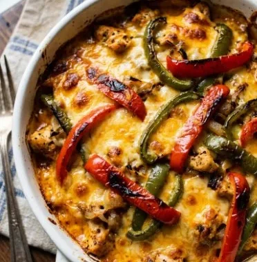 Cheesy Fajita Baked Chicken (Quick & Easy!) 2 Cheesy fajita baked chicken dish served on a plate with vibrant vegetables.