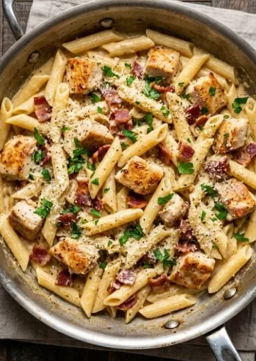 Delicious creamy chicken pasta served in a bowl with herbs