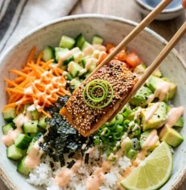 Crispy Salmon Bowls 2 Crispy salmon bowls garnished with fresh vegetables and sauce
