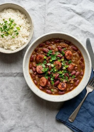 Bowl of easy red beans and rice with spices and herbs, garnished and ready to serve.