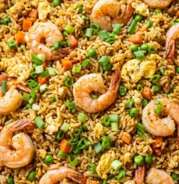 Bowl of homemade Chinese shrimp fried rice with colorful vegetables and shrimp.
