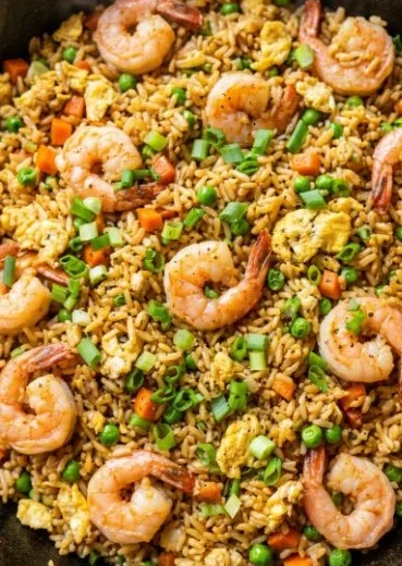 Bowl of homemade Chinese shrimp fried rice with colorful vegetables and shrimp.