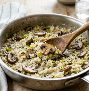 Delicious Leek Mushroom Cauliflower Risotto served in a bowl, garnished with herbs.